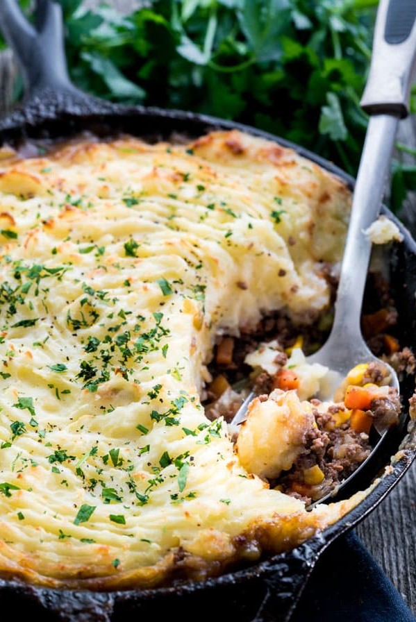 side view shot of a serving spoon taking a scoop of skillet shepherds pie