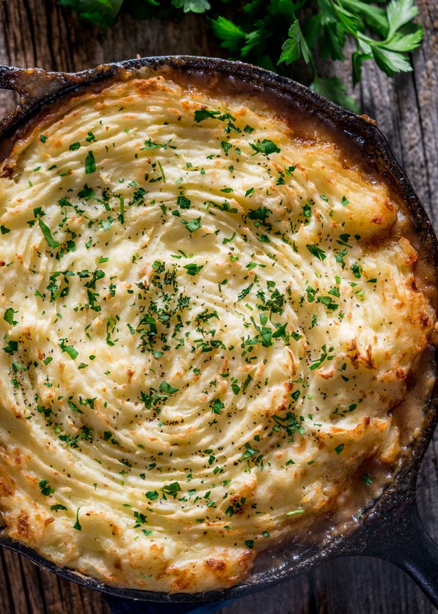 a skillet loaded with shepherd's pie topped with parsley