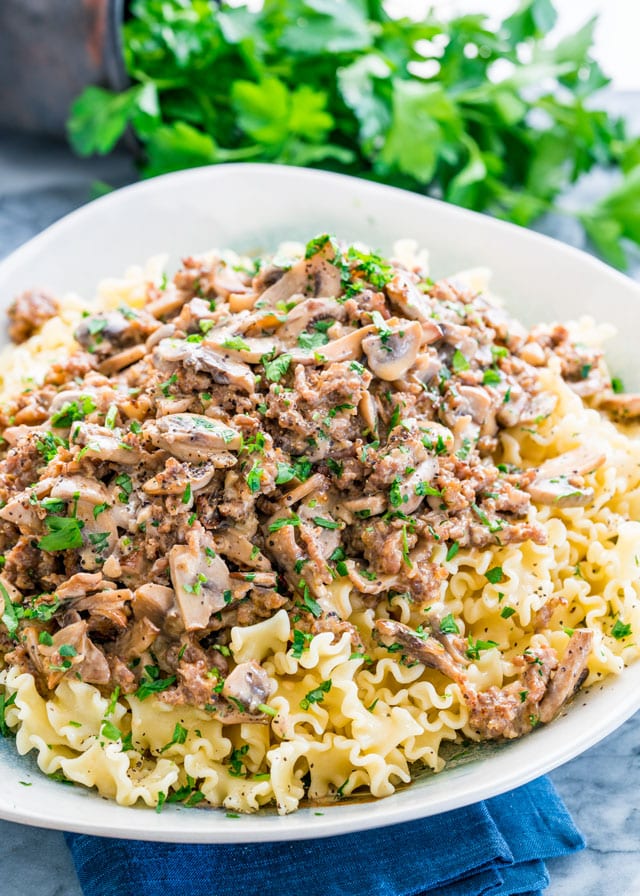creamy mushroom sauce over a bowl of pasta topped with parsley