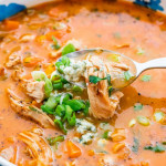 side view close up shot of a spoon taking a bite of buffalo chicken soup from a bowl