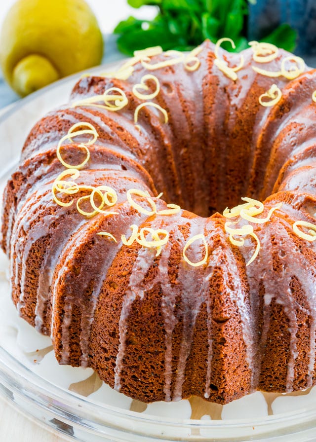 a bundt cake topped with glaze and curls of lemon zest