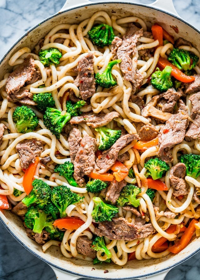 overhead of a pan full of noodles, beef, broccoli, and red pepper