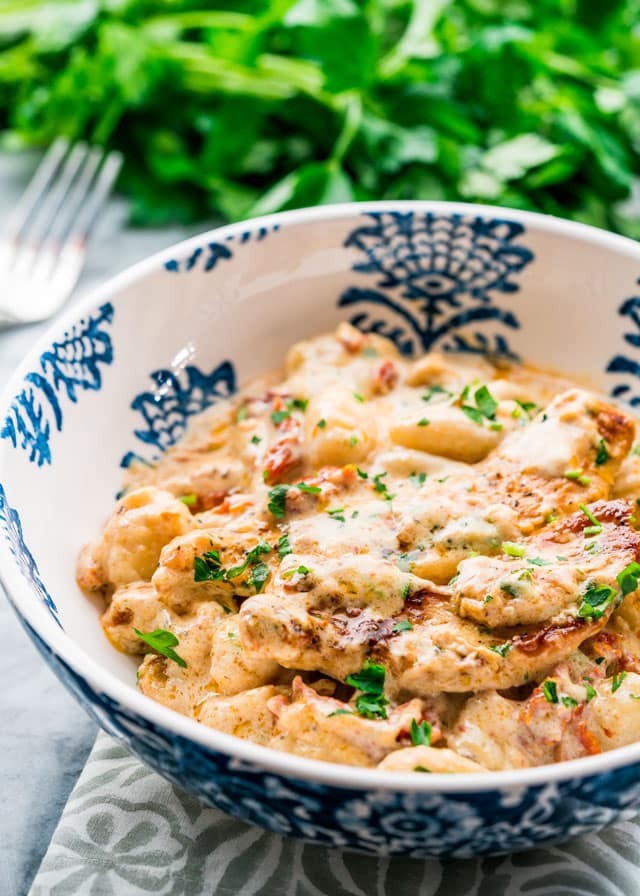 a bowl of gnocchi and chicken in a creamy sauce