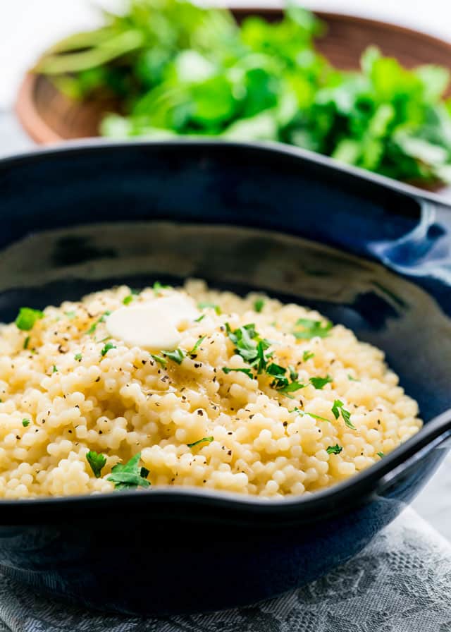 a bowl of freshly cooked couscous topped with pepper and parsley