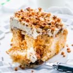 side view shot of a fork taking a bite of butter pecan dulce de leche poke cake