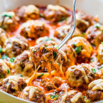 side view shot of a fork picking up a meatball from the enchilada meatball bake