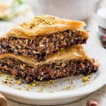 side view close up shot of two pieces of chocolate baklava stacked on a plate