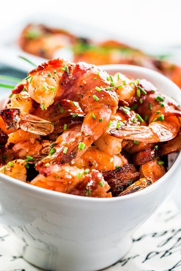 a bowl full of maple bbq glazed bacon wrapped shrimp
