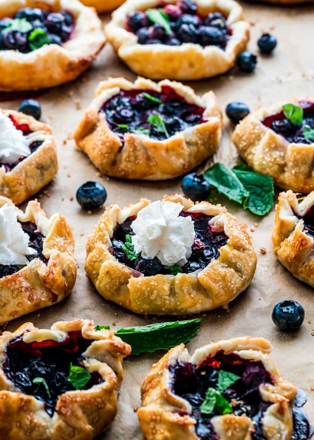 blueberry galettes on a baking sheet topped with whipped cream