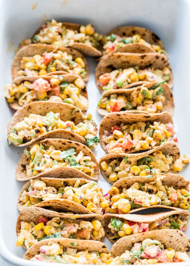 a pan full of mini tacos filled with corn salad