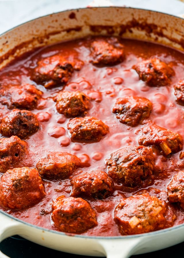 Moroccan meatballs cooking in a bubbling tomato sauce