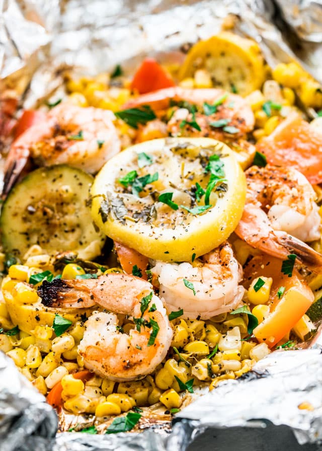 shrimp, corn, zucchini, and lemon slices in foil