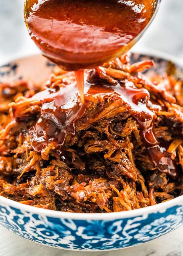pouring bbq sauce over pulled pork made in an instant pot