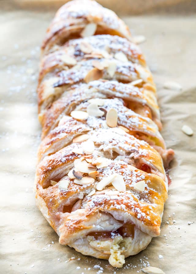 peaches and cream strudel fresh out of the oven topped with almonds and icing sugar