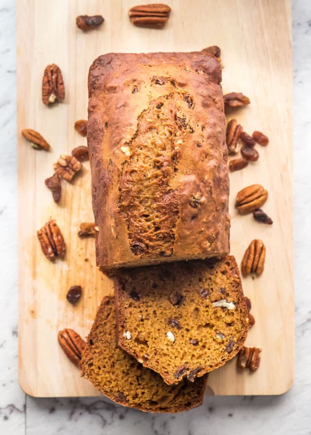 overhead shot of pumpkin cinnamon bread on a cutting board with pecans around it
