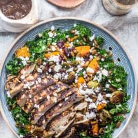 overhead shot of the warm kale salad with roasted butternut squash, sliced chicken breast and feta
