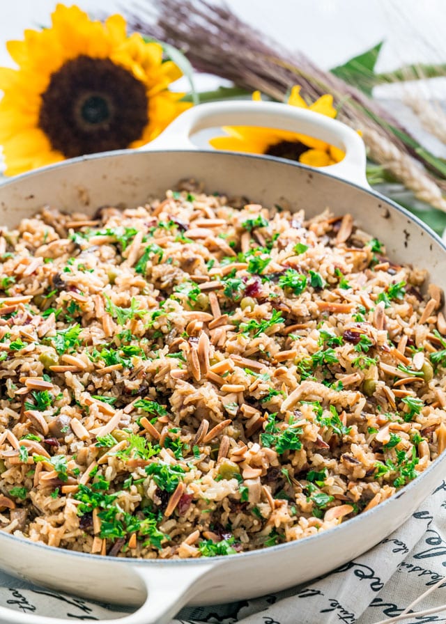 a pan full of harvest rice topped with toasted almonds and parsley