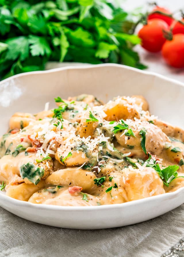 finished one pot chicken florentine gnocchi in a white bowl garnished with parmesan