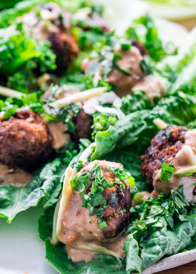 Closeup of Thai Meatball Lettuce Wraps topped with peanut sauce
