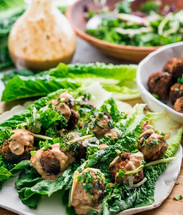 side view shot of three thai meatball lettuce wraps on a plate