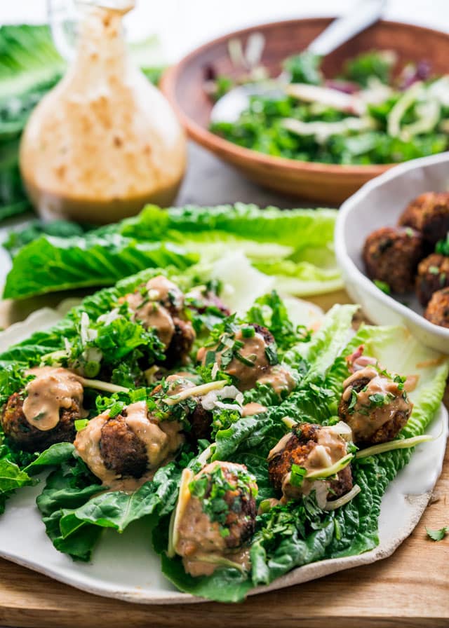 3 Thai Meatball Lettuce Wraps on a plate topped with peanut sauce