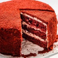 side view shot of a red velour cake with a slice missing and another slice cut