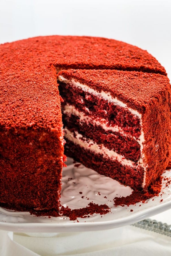 side view shot of a red velour cake with a slice missing and another slice cut
