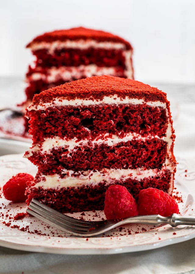 A slice of Red Velour Cake garnished with raspberries