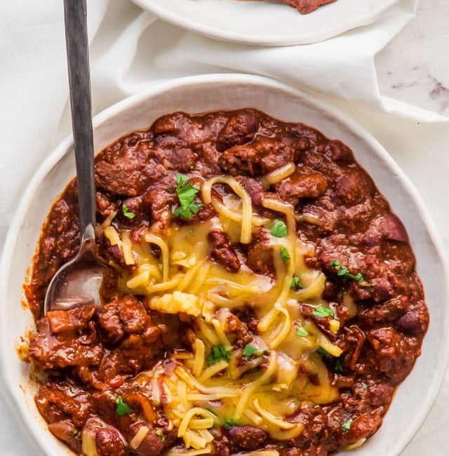 overhead shot of a bowl of chili topped with shredded cheddar cheese