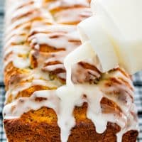 side view shot of lemon poppy seed bread being drizzled with icing