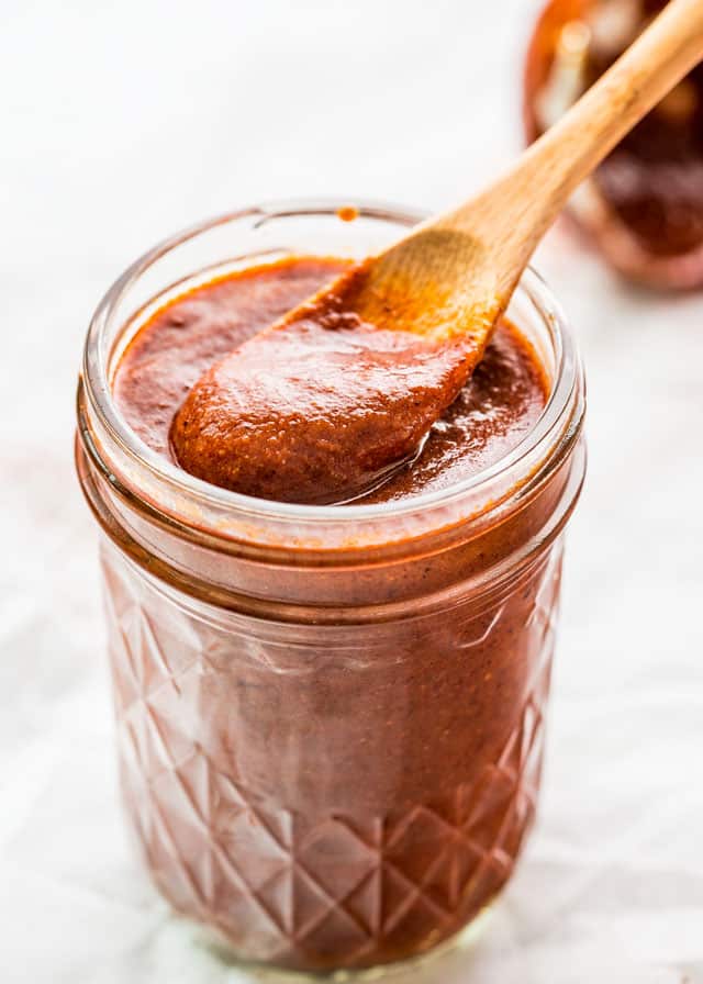 finished enchilada sauce in a jar with a spoon inside