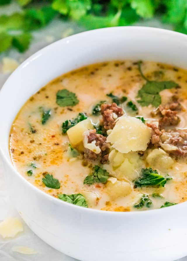 zuppa toscana in a white bowl with Parmesan cheese