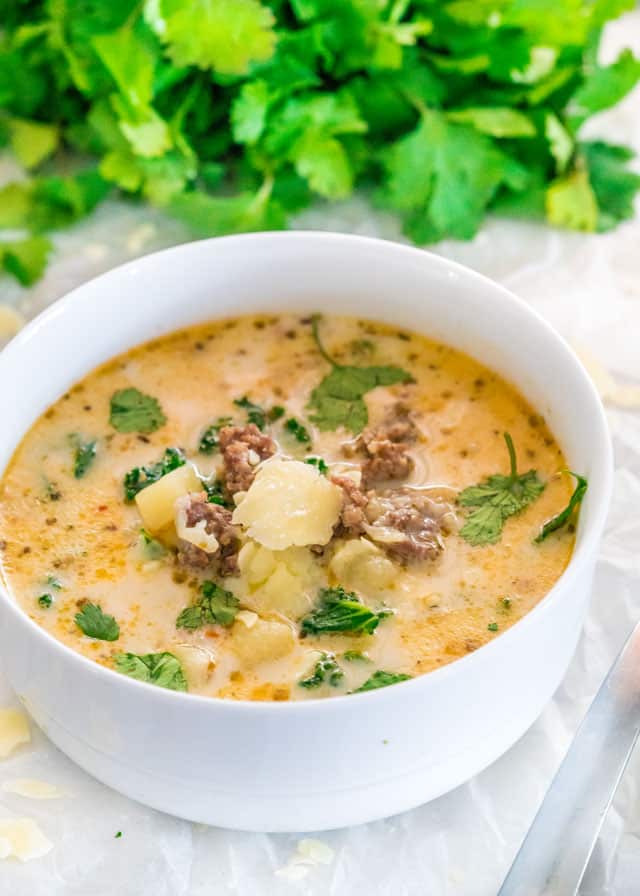 Instant Pot Zuppa Toscana in a white bowl with parsley in the background