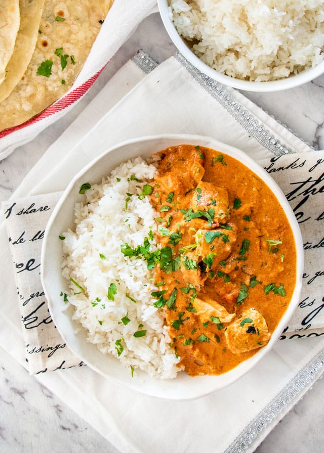 overhead shot of Chicken Tikka Masala in a white plate served along rice