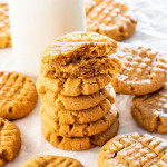 side view shot of a stack of peanut butter cookies, the top cookie is split in half and stacked