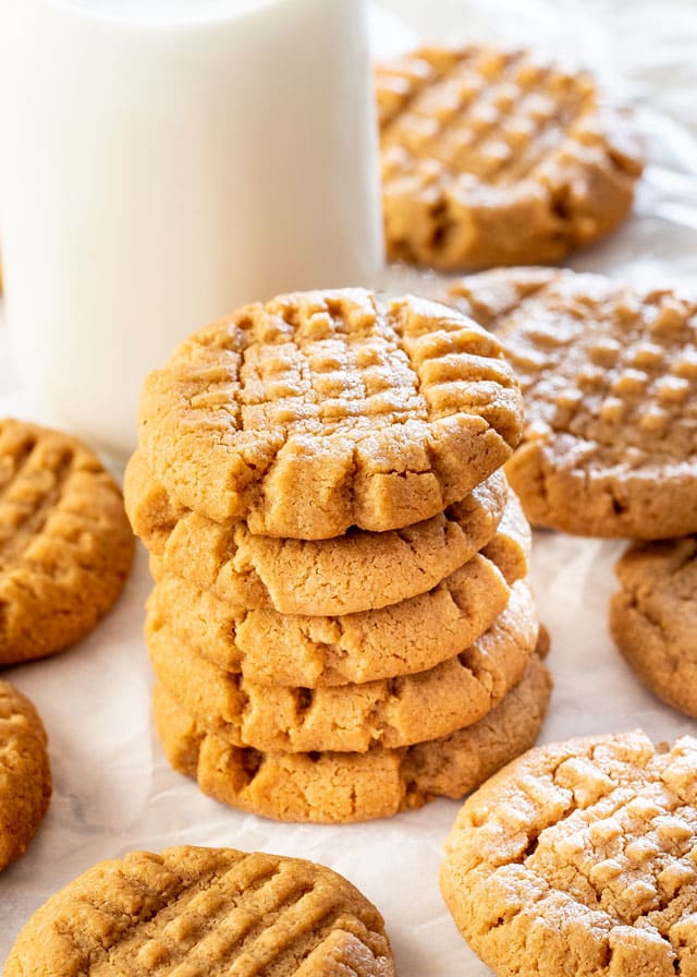 3 Ingredient Peanut Butter Cookies stacked with glass of milk in the background
