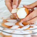 peeling Instant Pot Hard Boiled Eggs in a bowl with ice water