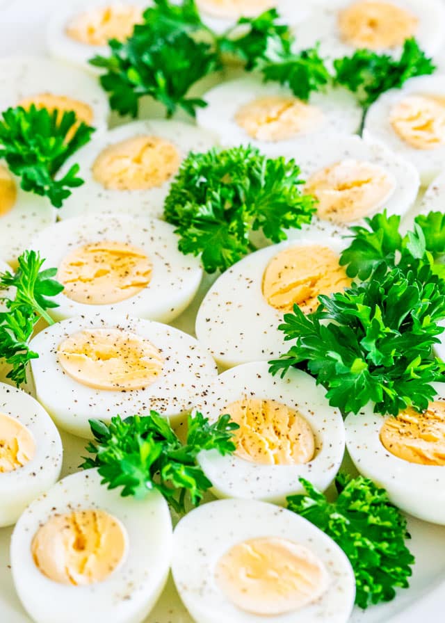 Instant Pot Hard Boiled Eggs cut in half on a white platter garnished with parsley