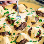 side view shot of a hand stabbing a fork into a philly cheese steak meatball
