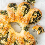 overhead shot of spinach feta wreath with a piece broken off