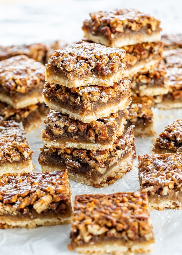 Pecan Pie Bars stacked sprinkled with a bit of powdered sugar