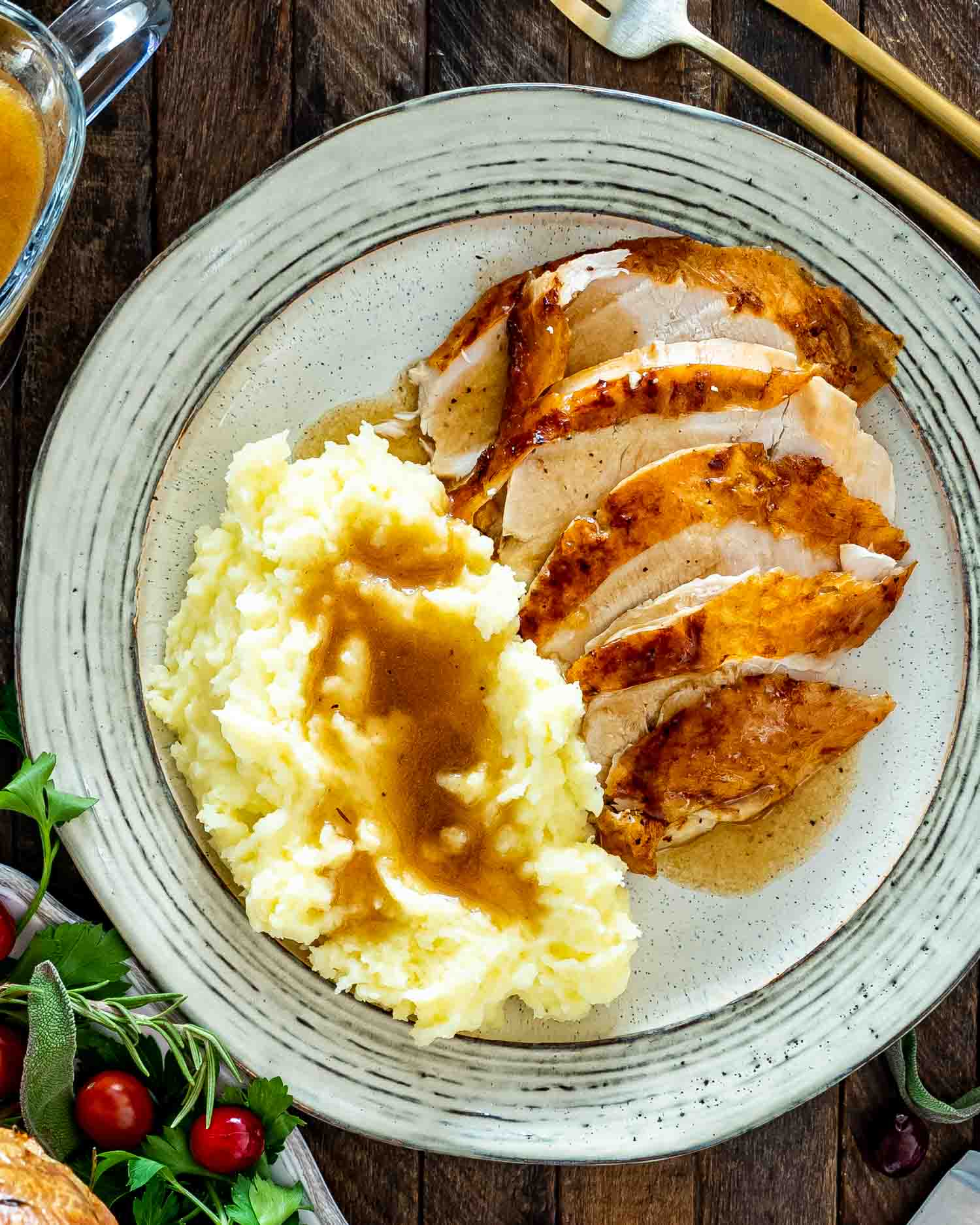 turkey breast sliced up with mashed potatoes and gravy on a plate.
