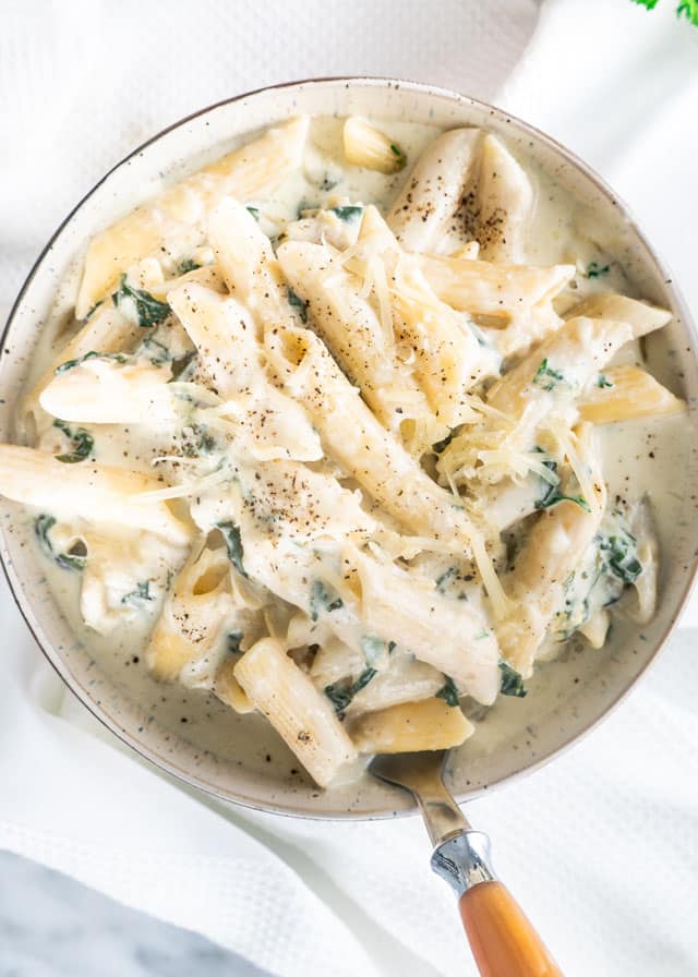 Spinach Artichoke Pasta in a bowl with a fork
