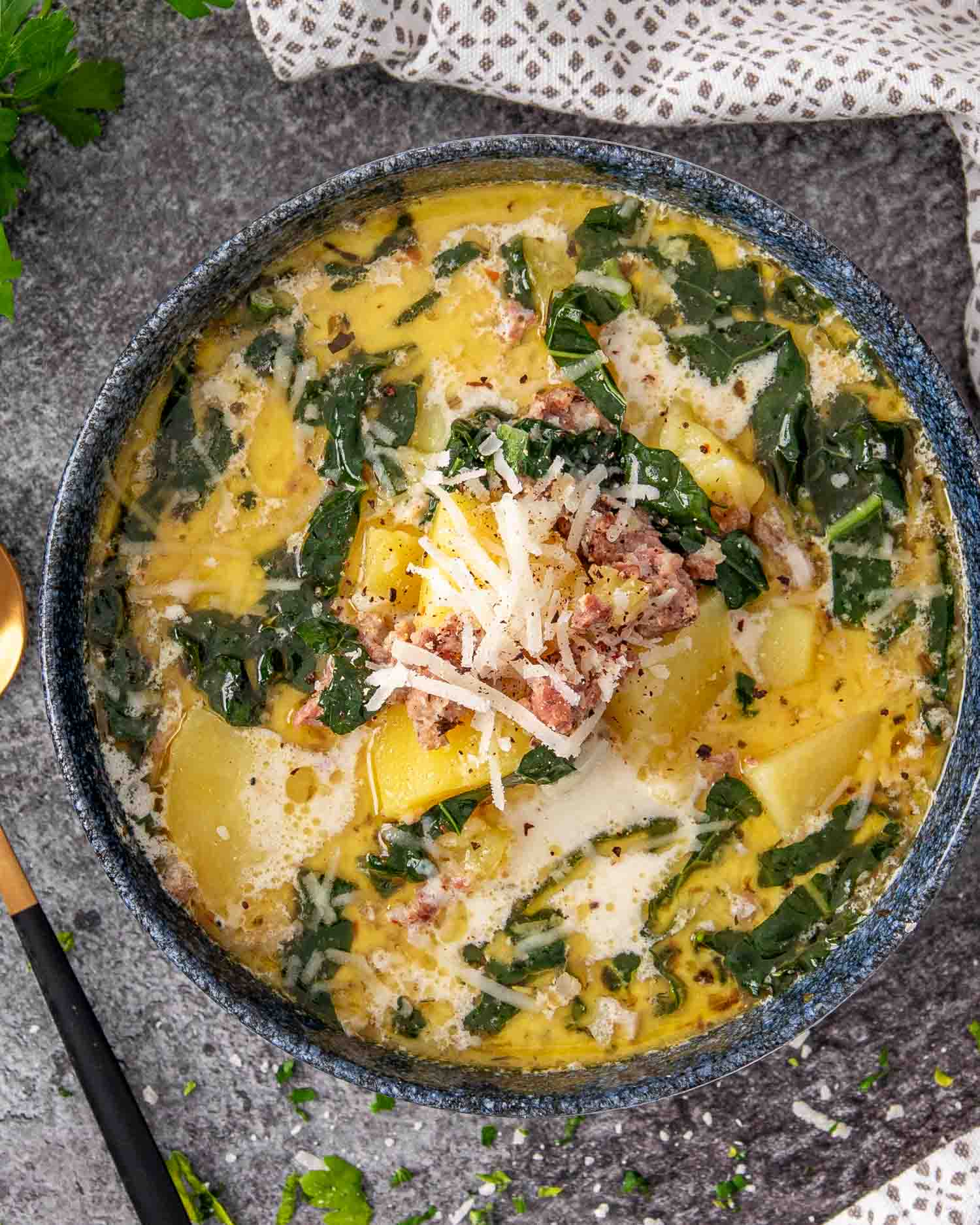 a blue bowl of zuppa toscana that was made in the instant pot.
