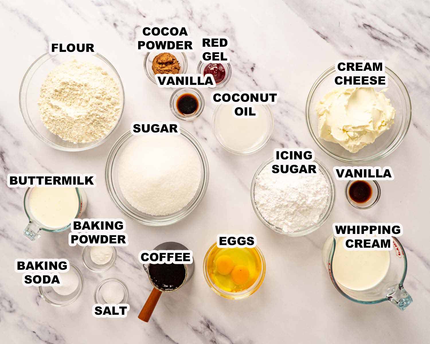 Ingredients for red velvet cake including flour cocoa powder coffee coconut oil eggs and cream cheese frosting components.