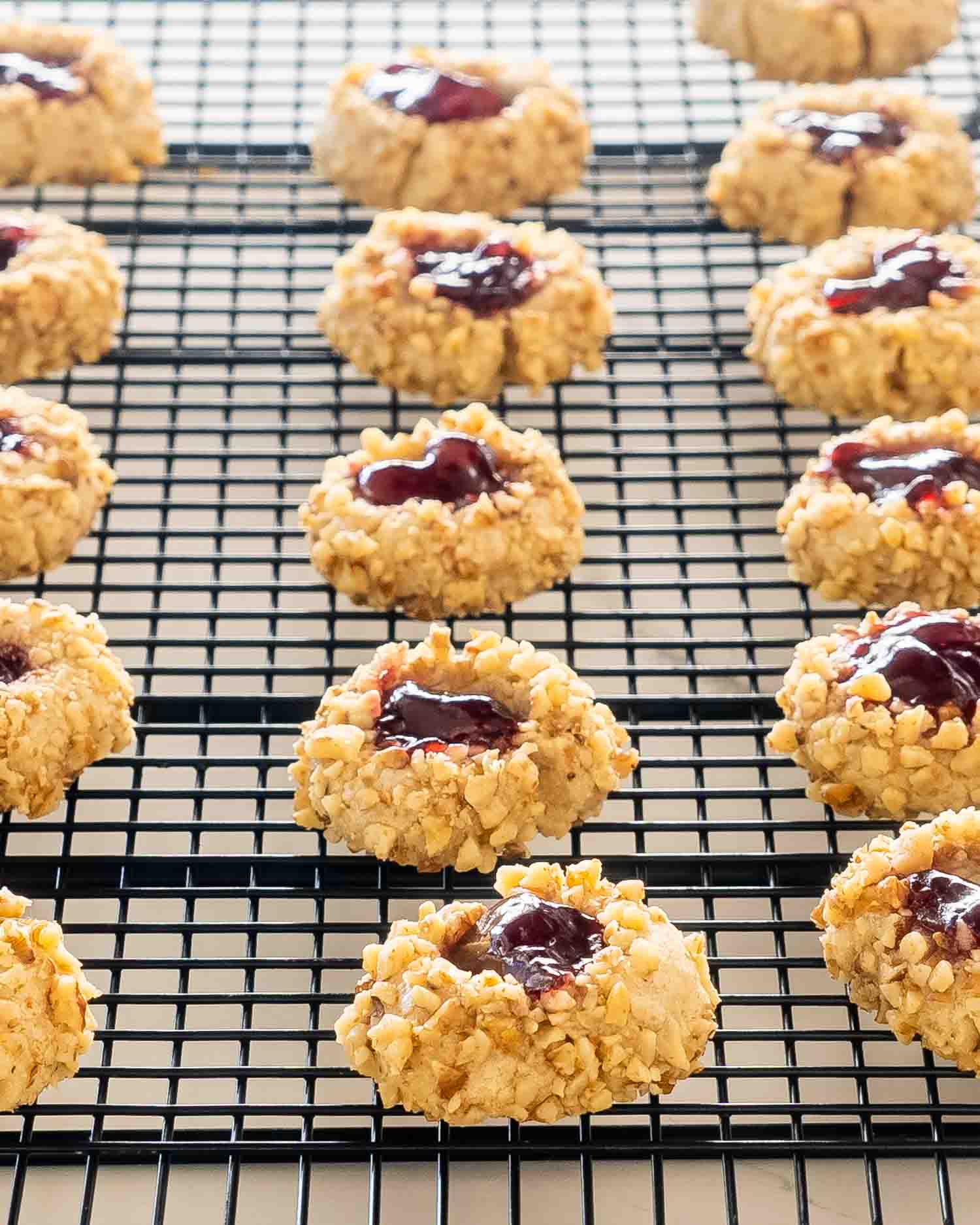 thumbprint cookies on a black cooling rack.