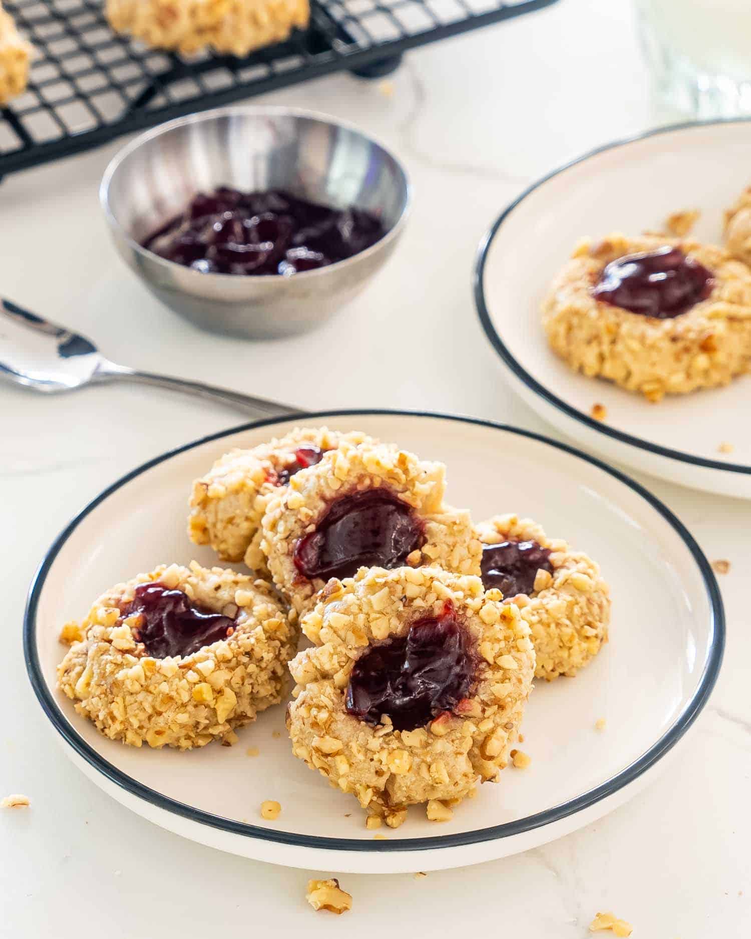 a few thumbprint cookies on a white plate.