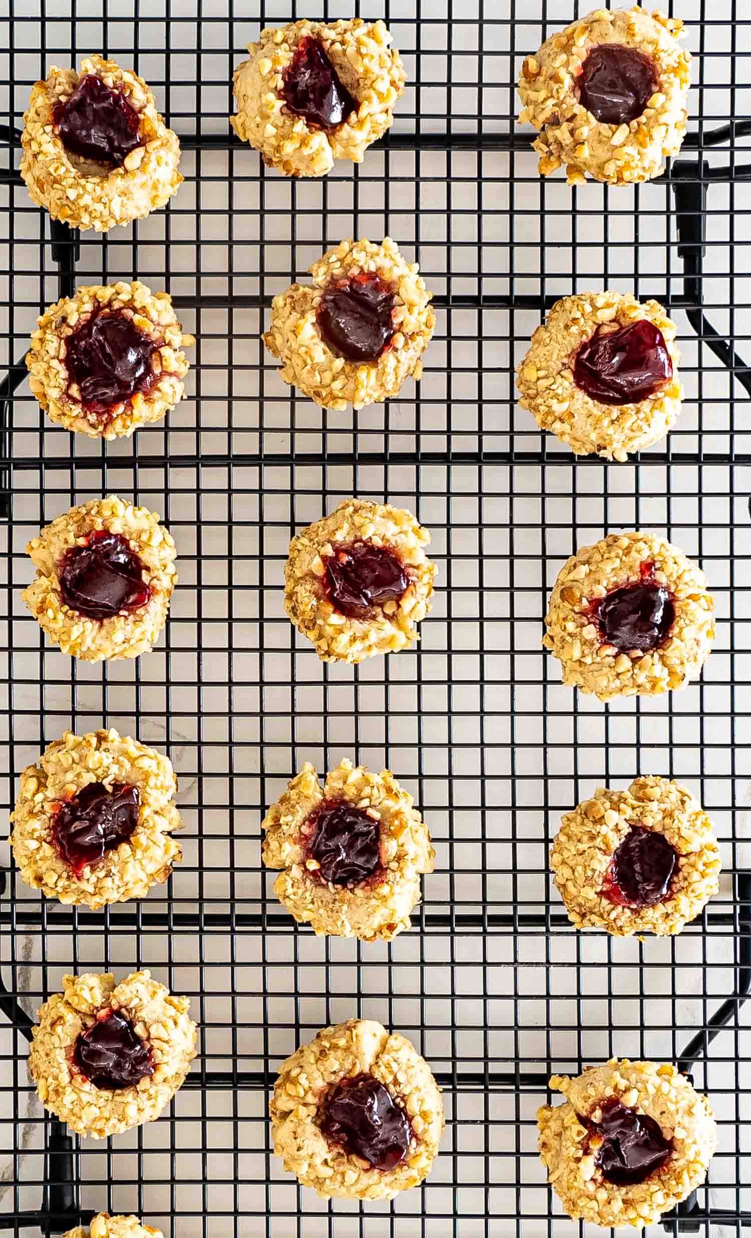 thumbprint cookies on a black cooling rack.