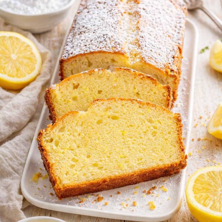 sliced up lemon yogurt cake on a white platter.