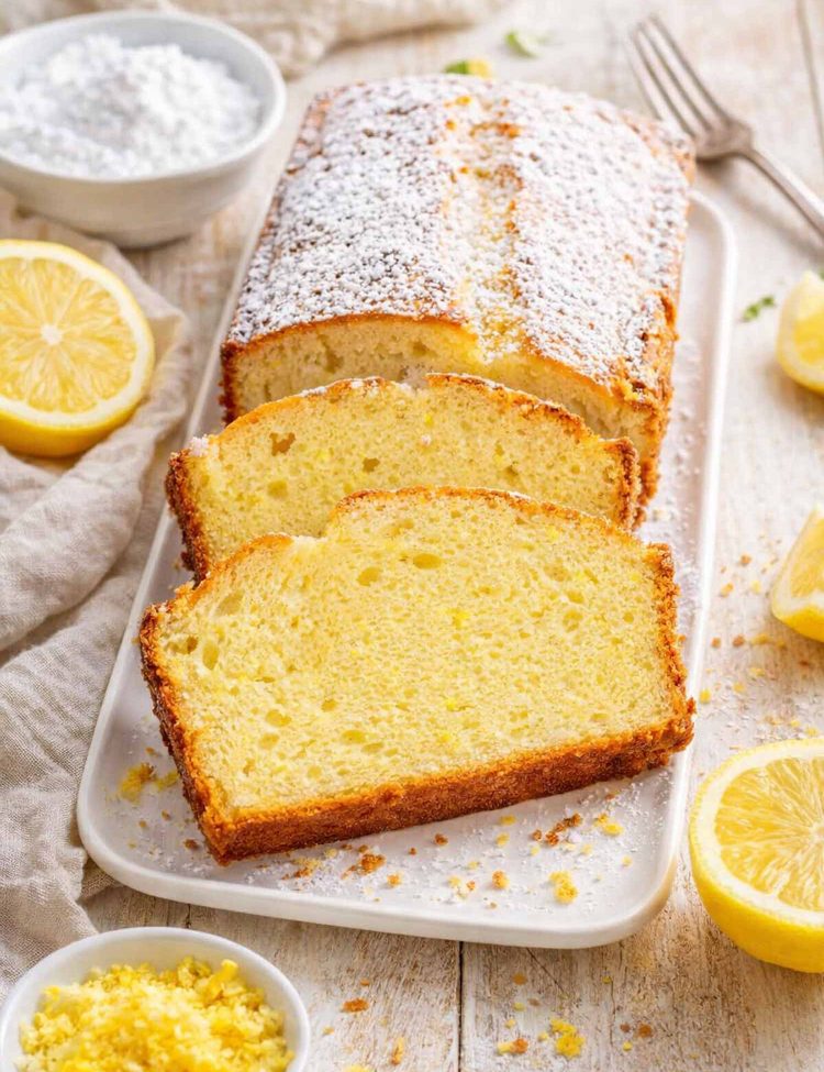 sliced up lemon yogurt cake on a white platter.